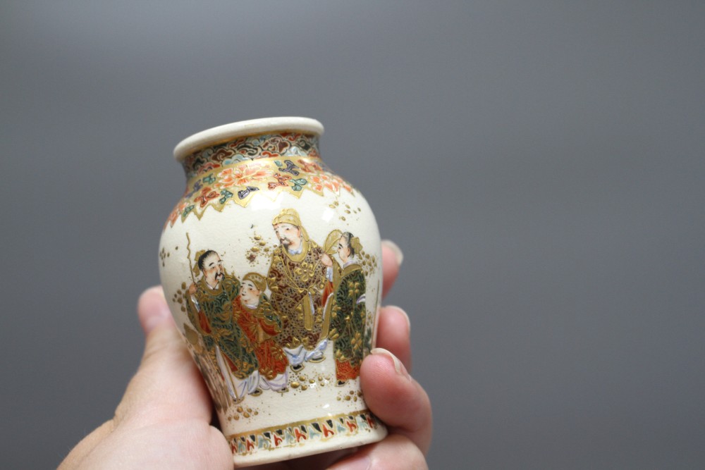 A small Cantonese porcelain teapot, a Satsuma vase, a silkwork panel, a doll and a broken soapstone figure